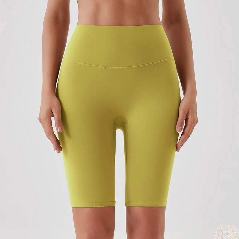 Athletic women's high waist tight shorts in yellow, highlighting the comfortable nylon blend and secure fit for sports activities.